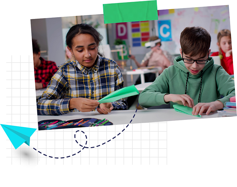 Two middle school students making paper airplanes in class